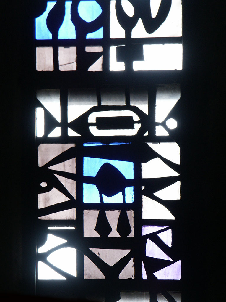 Abstract stained-glass panel with bold black lines forming geometric shapes around softly glowing white, blue, and purple glass sections.