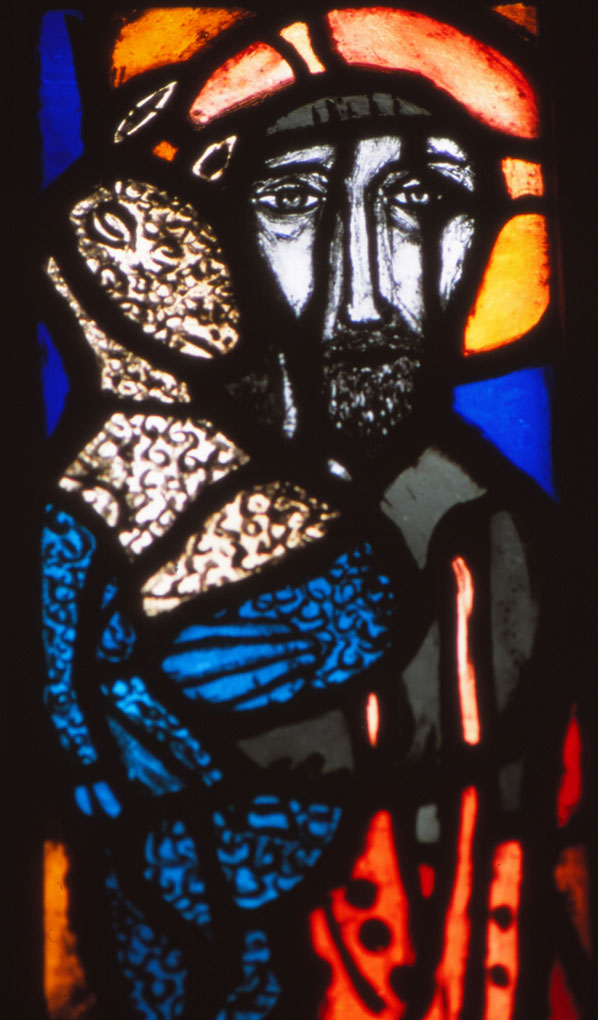 Stained-glass image of a solemn figure with a halo holding a patterned lamb, rendered in vivid blue, red, orange, and black outlines.