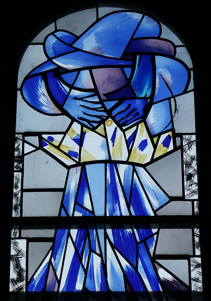 Stained-glass window with abstract blue and yellow shapes forming two figures embracing, rendered in bold, expressive lines.