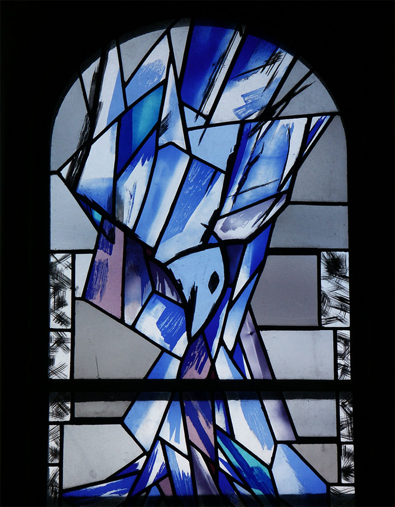 Stained-glass window composed of angular blue and white shapes forming an abstract figure, with bold black outlines and an arched top.