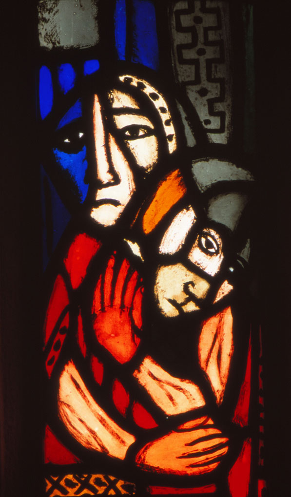 Stained-glass panel showing two sorrowful figures in vivid red, blue, and orange, one cradling the other in a tender, emotional embrace.
