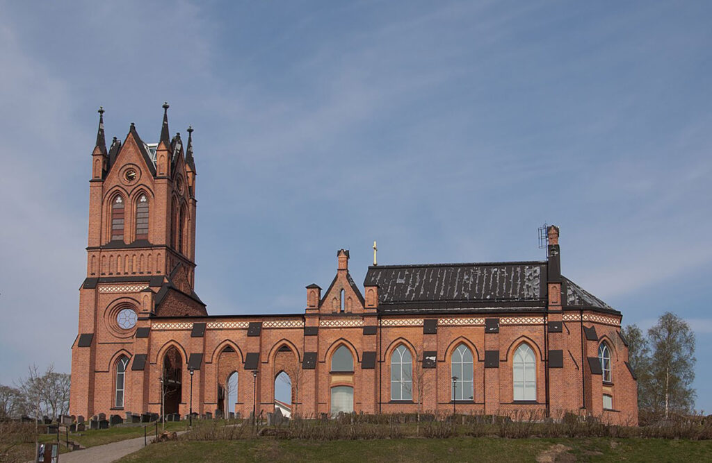 Trönö red brick church under a blue sky.