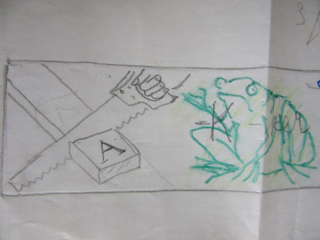 Childlike drawing of a saw cutting wood near a block with the letter “A,” next to a green frog marked with “K.”